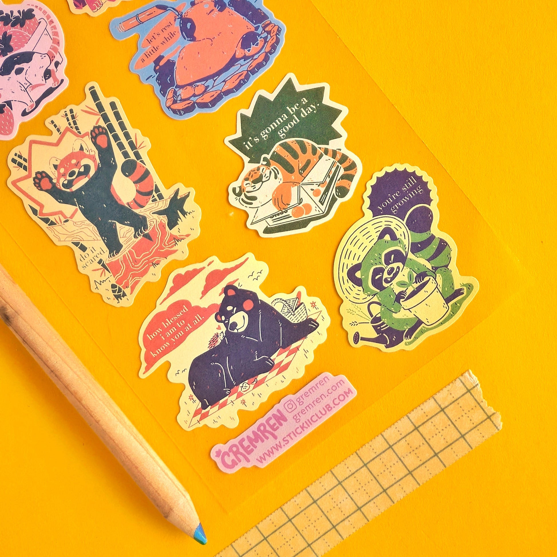 Colorful stickers with cartoon characters on a yellow background with a pencil and washi tape.